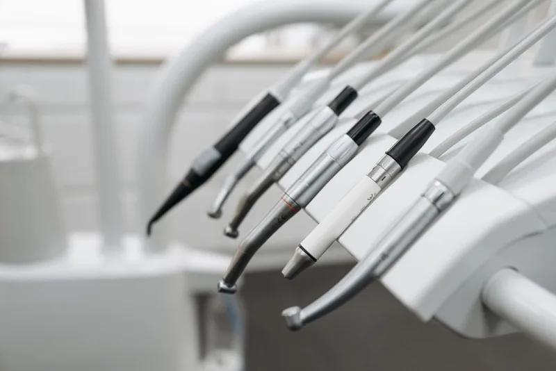 Illustrative close-up of dental handpieces resting on a treatment unit